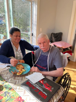 Compassionate Lighthouse Elder Care caregiver assisting a senior client at their dining table